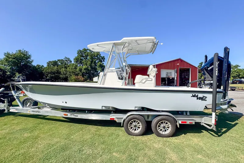 Slide: The Image of 2026 SeaVee 270Z boat on trailer, parked on grass near red barn. - 1