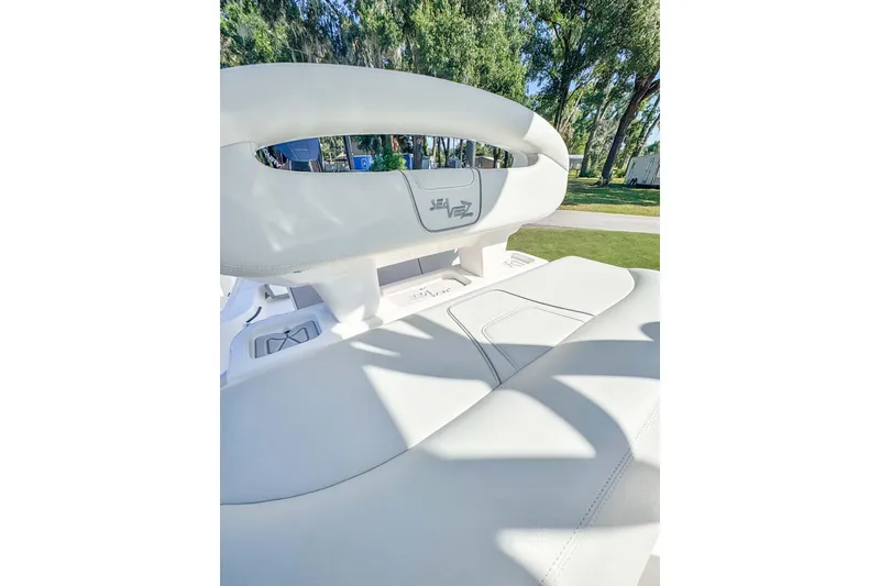 Slide: The Image of 2026 SeaVee 270Z boat interior with white seating and logo, surrounded by greenery. - 15