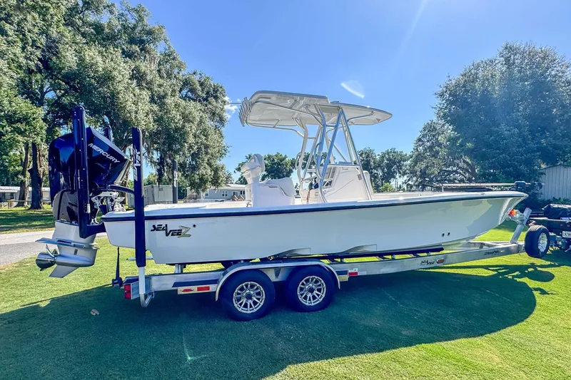Slide: The Image of 2026 SeaVee 270Z boat on trailer, parked on grass under clear blue sky. - 2