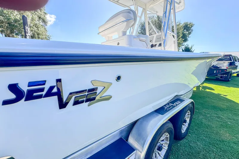 Slide: The Image of 2026 SeaVee 270Z boat on trailer, side view with logo, sunny day. - 5
