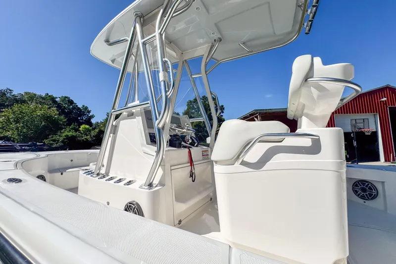 Slide: The Image of 2026 SeaVee 270Z boat interior with helm and seating, under clear blue sky. - 7