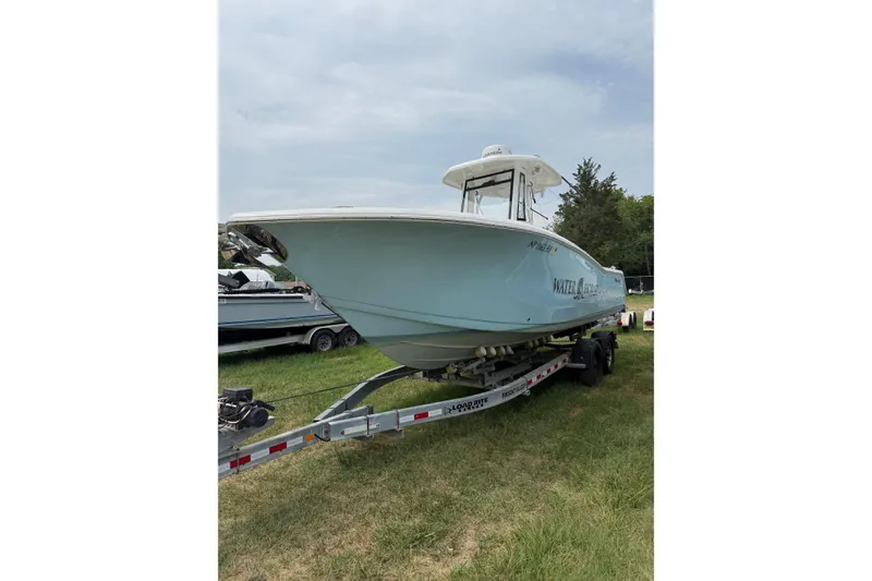 Slide: The Image of 2022 Tidewater 272 CC Adventure boat on trailer, parked on grass. - 3