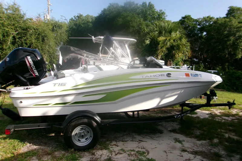 The Image of 2024 Tahoe T16 boat with Mercury engine on trailer, parked outdoors. - 1