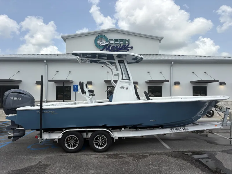 The Image of A Tidewater 2500 Carolina Bay boat on a trailer in front of a building with "Ocean Marine" sign. - 1