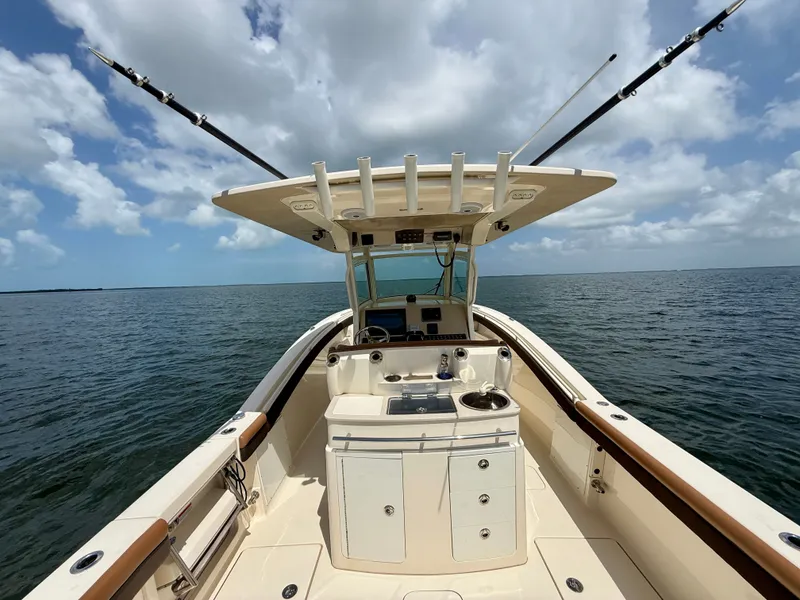 Slide: The Image of 2014 Scout 320 LXF on calm water with fishing rods and clear view. - 12