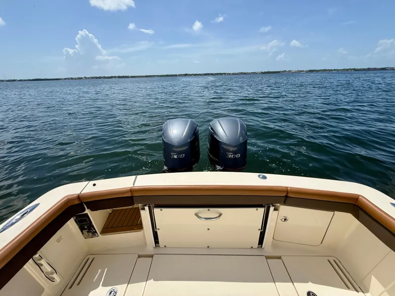 Slide: The Image of 2014 Scout 320 LXF with twin outboard engines on calm water. - 13