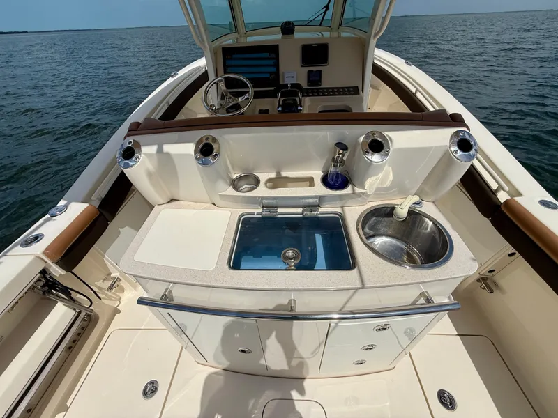 Slide: The Image of The image shows the cockpit of a 2014 Scout 320 LXF boat on the water. - 16