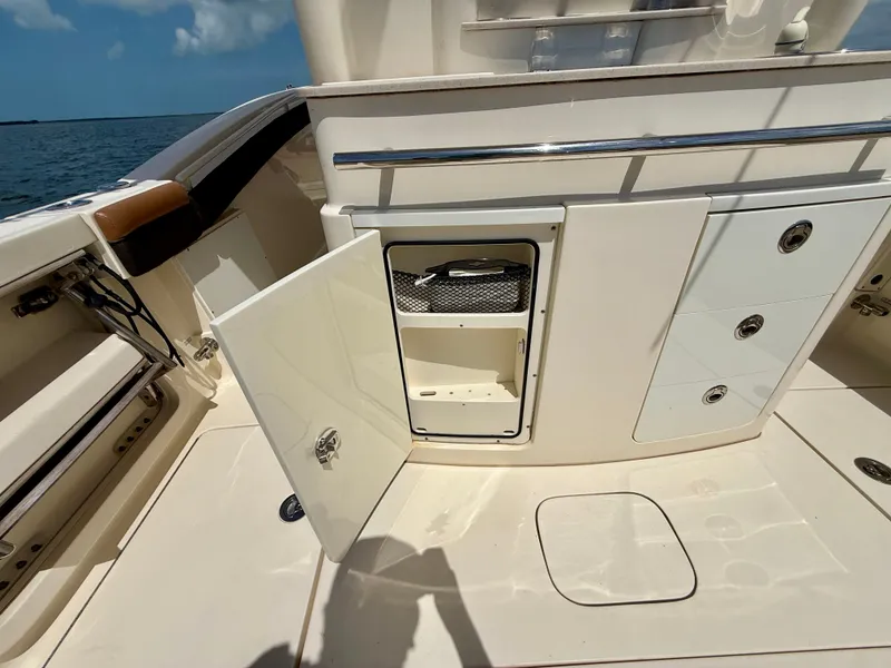 Slide: The Image of Open storage compartment on a Scout 320 LXF boat, featuring drawers and a compartment. - 17