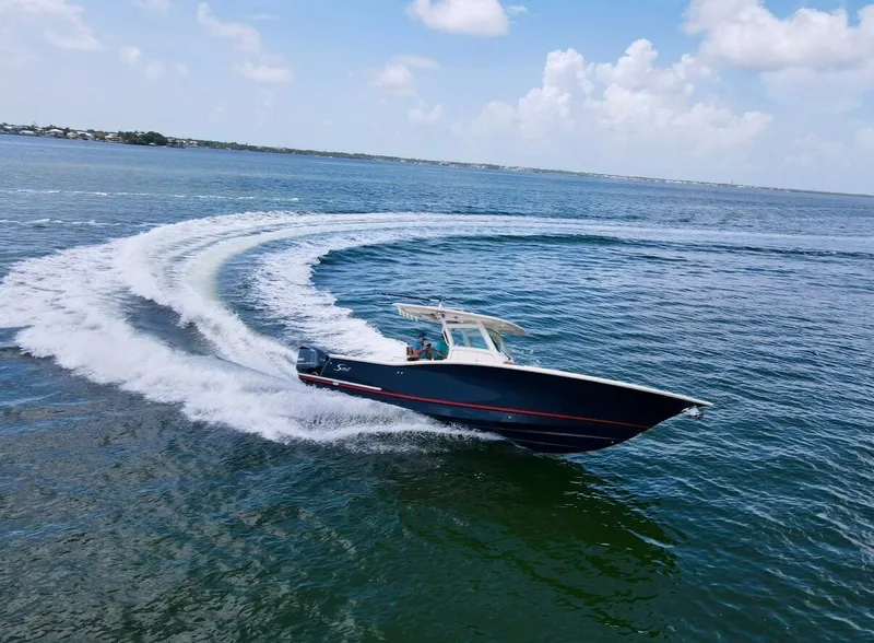 Slide: The Image of A 2014 Scout 320 LXF boat speeds across the water, leaving a trail behind. - 2