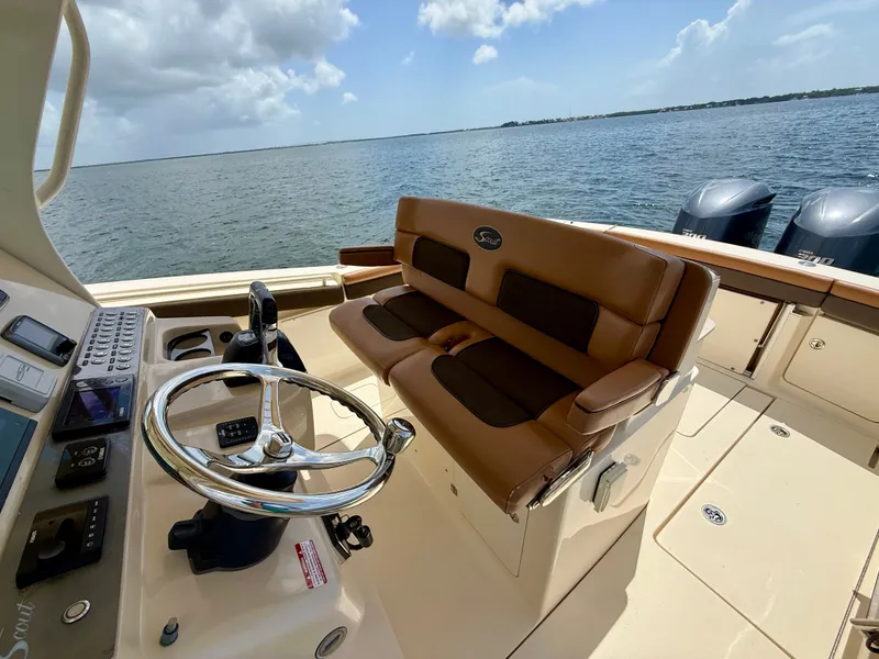 Slide: The Image of The image shows the cockpit of a 2014 Scout 320 LXF boat with brown seating. - 5