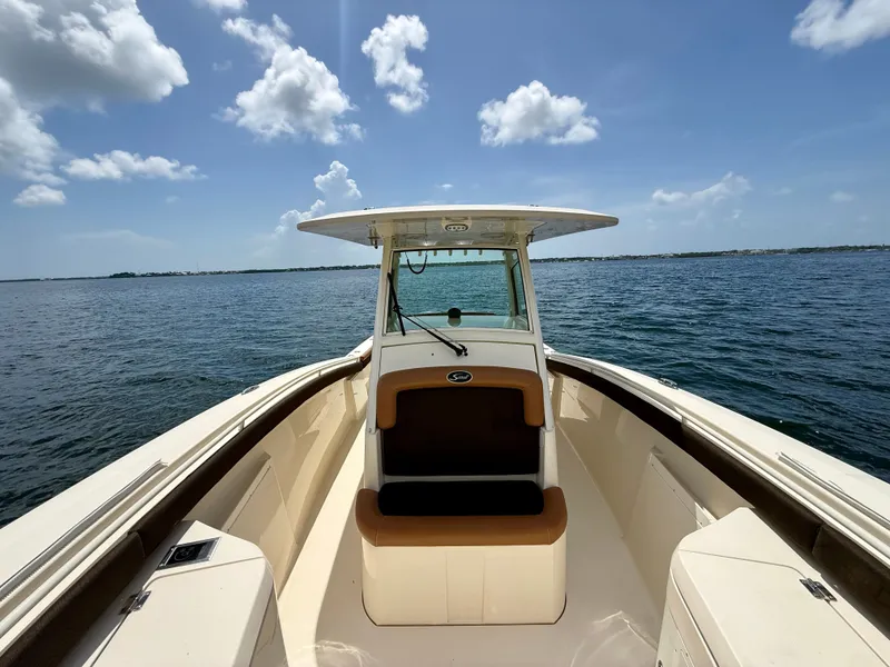 Slide: The Image of 2014 Scout 320 LXF on calm water under a blue sky with white clouds. - 7