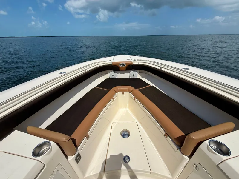 Slide: The Image of The image shows the bow of a Scout 320 LXF boat on the water. - 9