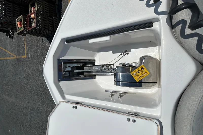Slide: The Image of Anchor compartment of 2018 Sea Fox 266 Commander boat, featuring a secured anchor and warning label. - 28