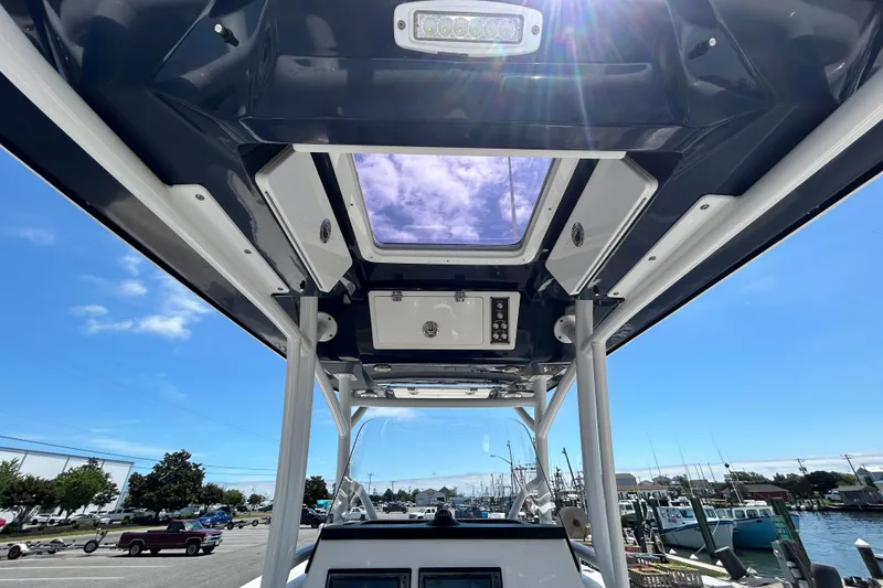 Slide: The Image of 2018 Sea Fox 266 Commander boat interior with sunroof and control panel, docked at marina. - 16