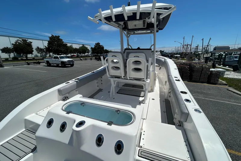 Slide: The Image of 2018 Sea Fox 266 Commander boat interior with seating and storage, parked in a marina. - 9