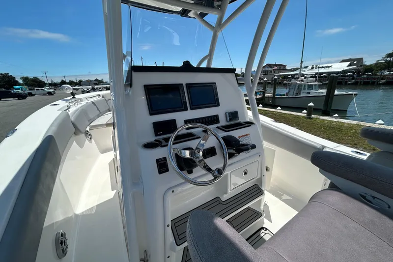 Slide: The Image of 2018 Sea Fox 266 Commander boat cockpit with steering wheel and navigation screens. - 13