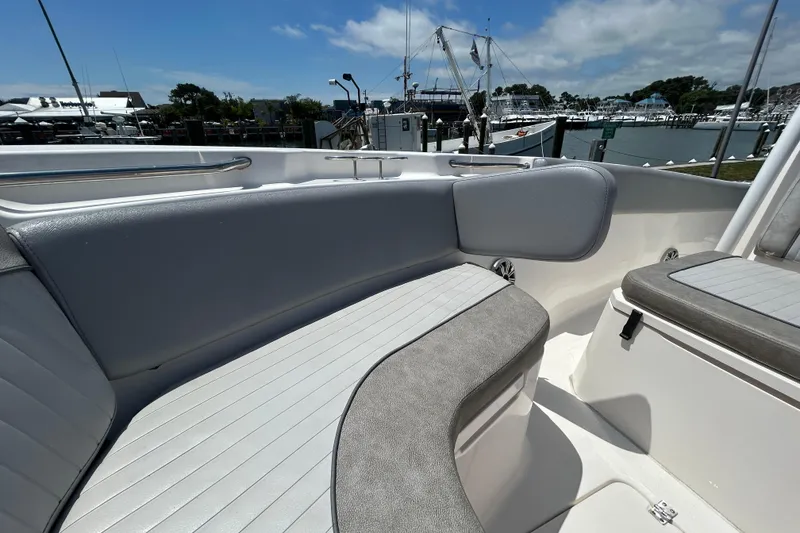 Slide: The Image of 2018 Sea Fox 266 Commander boat interior with cushioned seating, docked at marina. - 25