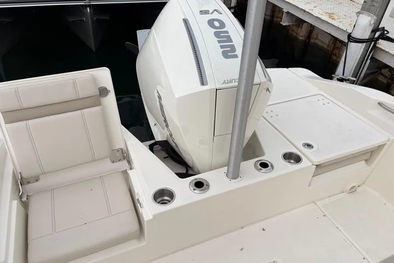 Slide: The Image of 2026 Boston Whaler 22 Dauntless boat with Mercury engine, featuring white seating and cup holders. - 13