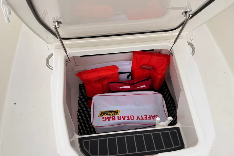 Slide: The Image of Storage compartment of 2026 Boston Whaler 22 Dauntless with safety gear and life jackets. - 18
