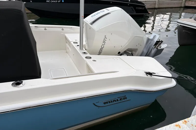 Slide: The Image of 2026 Boston Whaler 22 Dauntless boat with Mercury engine docked in marina. - 2