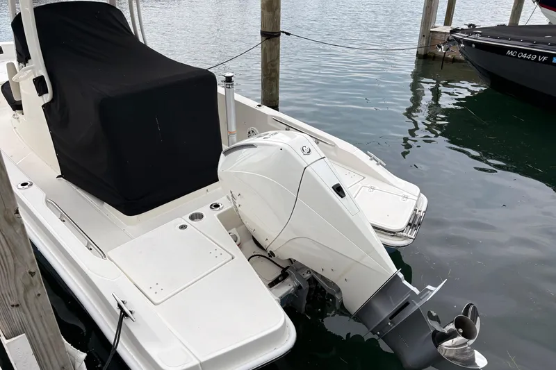 Slide: The Image of 2026 Boston Whaler 22 Dauntless boat docked, featuring a covered seating area and outboard motor. - 3