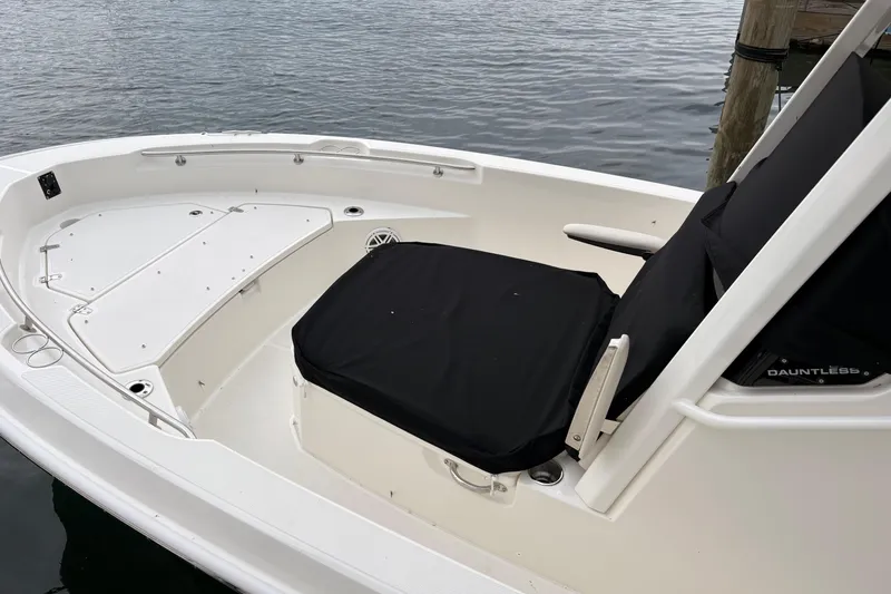 Slide: The Image of 2026 Boston Whaler 22 Dauntless boat interior with seating and storage, docked by water. - 4