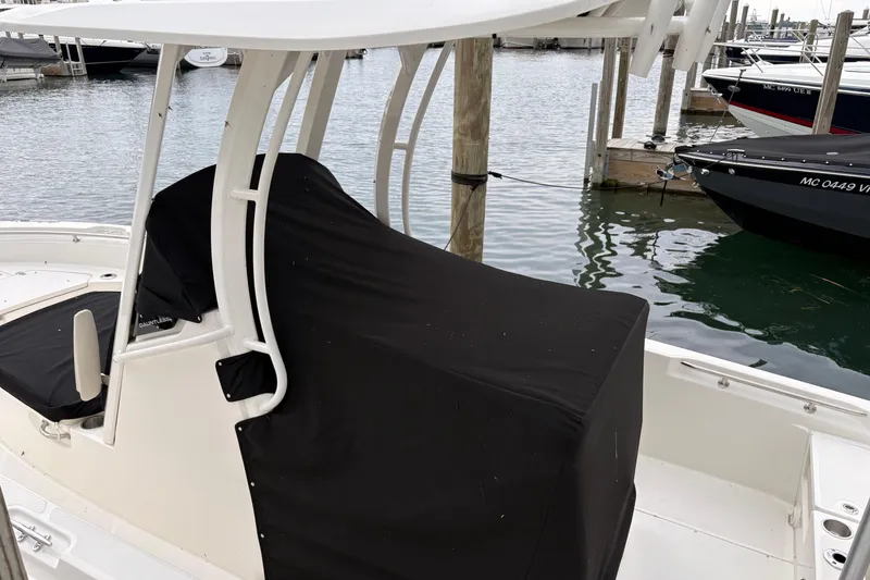 Slide: The Image of 2026 Boston Whaler 22 Dauntless boat docked, featuring a covered console and T-top. - 5