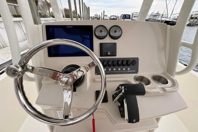 Slide: The Image of 2026 Boston Whaler 22 Dauntless boat dashboard with steering wheel and controls. - 7
