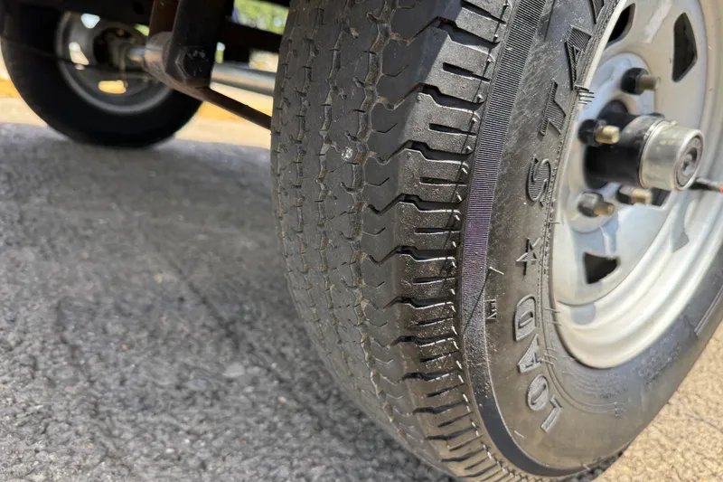 Slide: The Image of Close-up of a 2019 Tracker Pro 160 trailer tire on asphalt surface. - 29