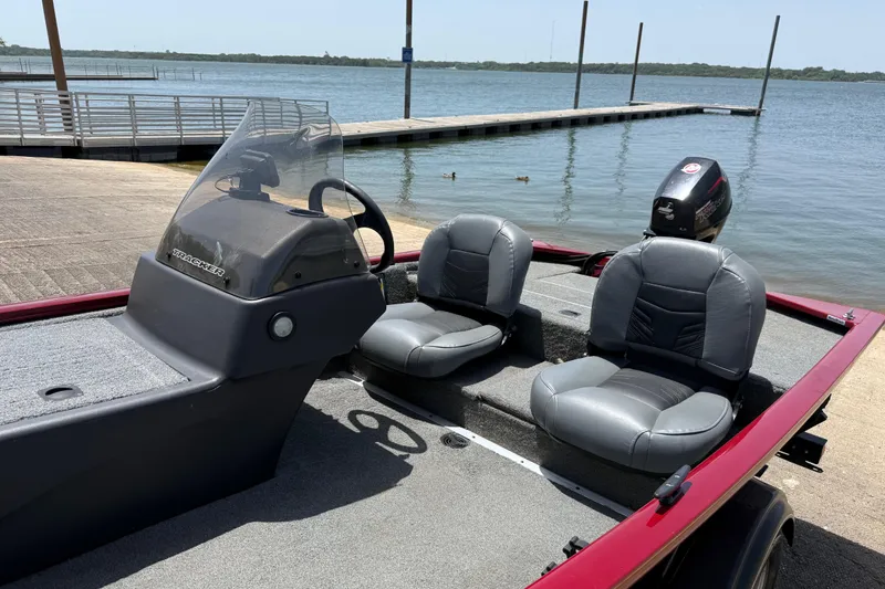 Slide: The Image of 2019 Tracker Pro 160 boat with dual seats, docked by a serene lake. - 22