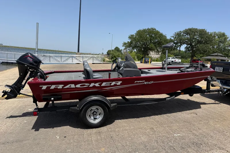 Slide: The Image of 2019 Tracker Pro 160 boat on trailer, parked outdoors under clear sky. - 13