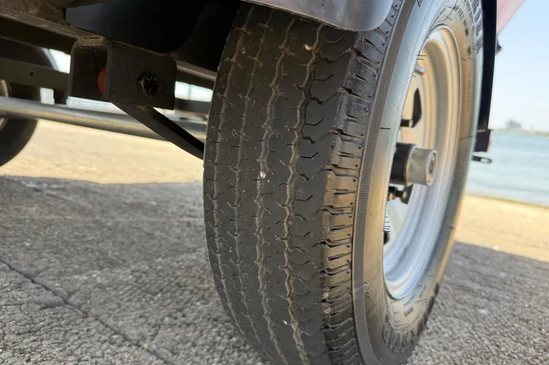 Slide: The Image of Close-up of a 2019 Tracker Pro 160 trailer tire on a concrete surface near water. - 31