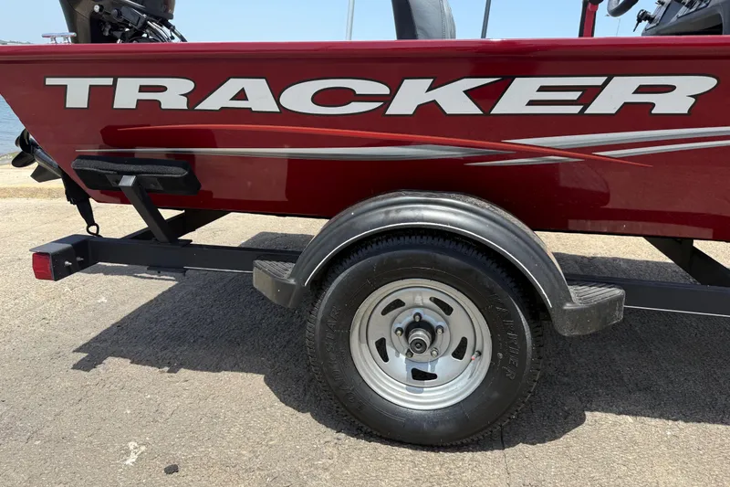 Slide: The Image of 2019 Tracker Pro 160 boat on trailer, red with bold logo, parked on concrete. - 28