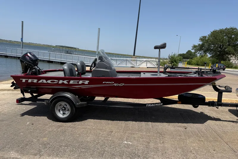 Slide: The Image of 2019 Tracker Pro 160 boat on trailer near a lakeside dock. - 14
