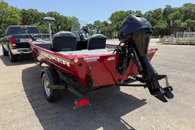 Slide: The Image of 2019 Tracker Pro 160 boat on trailer, parked outdoors, with outboard motor. - 8