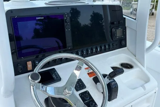 Slide: The Image of 2018 Sea Hunt Ultra 255 SE boat dashboard with steering wheel and navigation controls. - 12