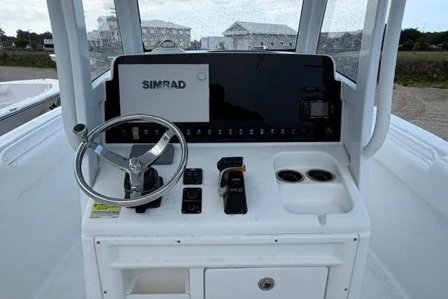 Slide: The Image of 2018 Sea Hunt Ultra 255 SE boat console with steering wheel and Simrad navigation system. - 13