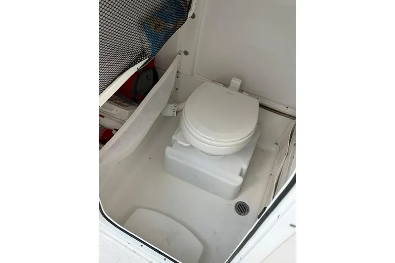 Slide: The Image of 2018 Sea Hunt Ultra 255 SE boat interior with compact marine toilet. - 14