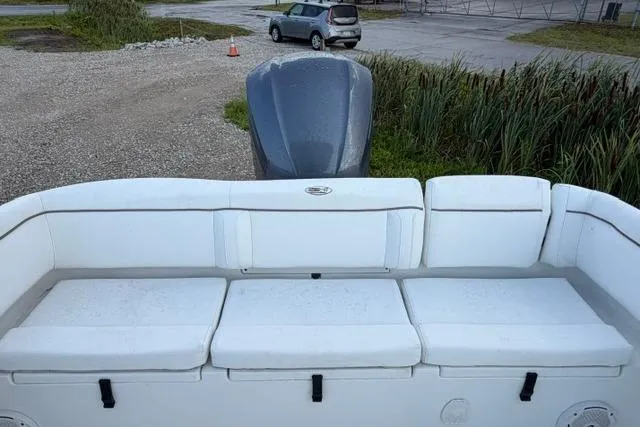 Slide: The Image of 2018 Sea Hunt Ultra 255 SE boat with white seating and outboard motor. - 18