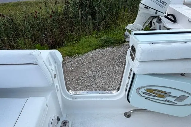 Slide: The Image of 2018 Sea Hunt Ultra 255 SE boat interior with open transom door and Suzuki outboard motor. - 21