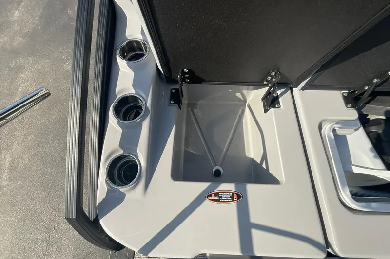 Slide: The Image of 2025 Harris Solstice 250 SLEC boat interior with cup holders and storage compartment. - 32