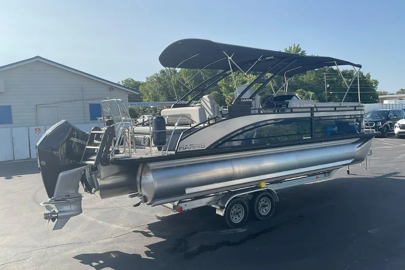 Slide: The Image of A 2025 Harris Solstice 250 SL pontoon boat on a trailer in a parking lot. - 7