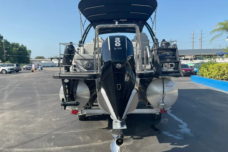 Slide: The Image of 2025 Harris Solstice 250 SLEC pontoon boat with 300 V8 engine in a parking lot. - 9