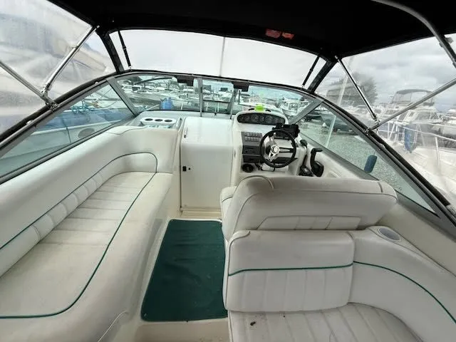 Slide: The Image of The image shows the cockpit of a 1994 Sea Ray 270 boat with white seating and a steering wheel. - 1