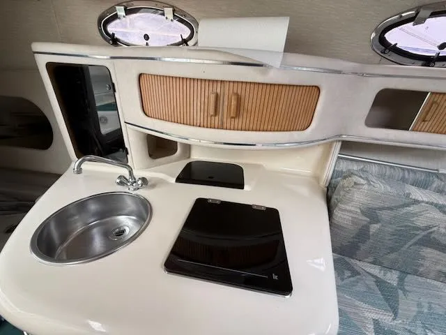 Slide: The Image of Interior of a 1994 Sea Ray 270 featuring a sink and stove. - 17