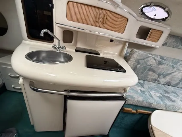 Slide: The Image of Interior of a 1994 Sea Ray 270 with sink, stove, and seating area. - 19