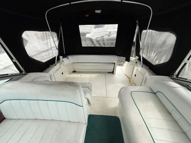 Slide: The Image of Interior of a 1994 Sea Ray 270 with white seating and black covers. - 2