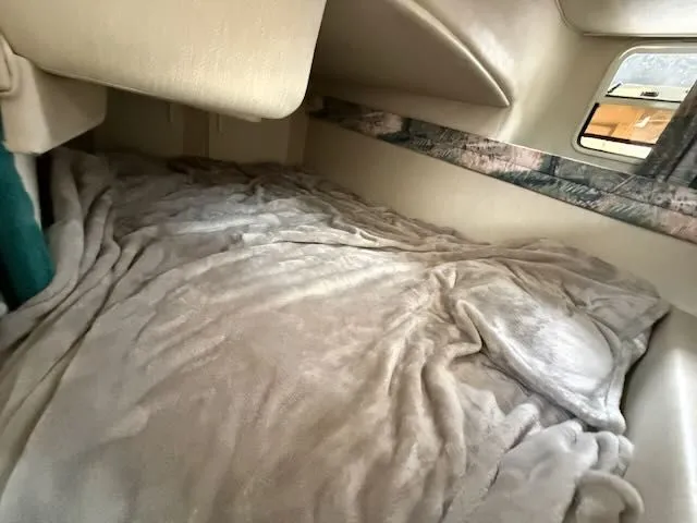Slide: The Image of Interior of a 1994 Sea Ray 270 with a cozy bed and window. - 20