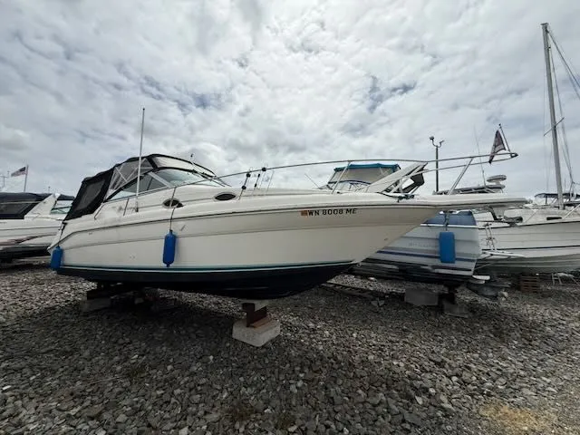 Slide: The Image of A 1994 Sea Ray 270 boat is on a gravel lot, surrounded by other boats. - 22