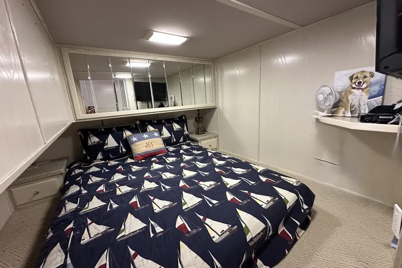 Slide: The Image of Cozy bedroom with nautical-themed bedding, mirrored wall, and dog artwork on a shelf. - 11